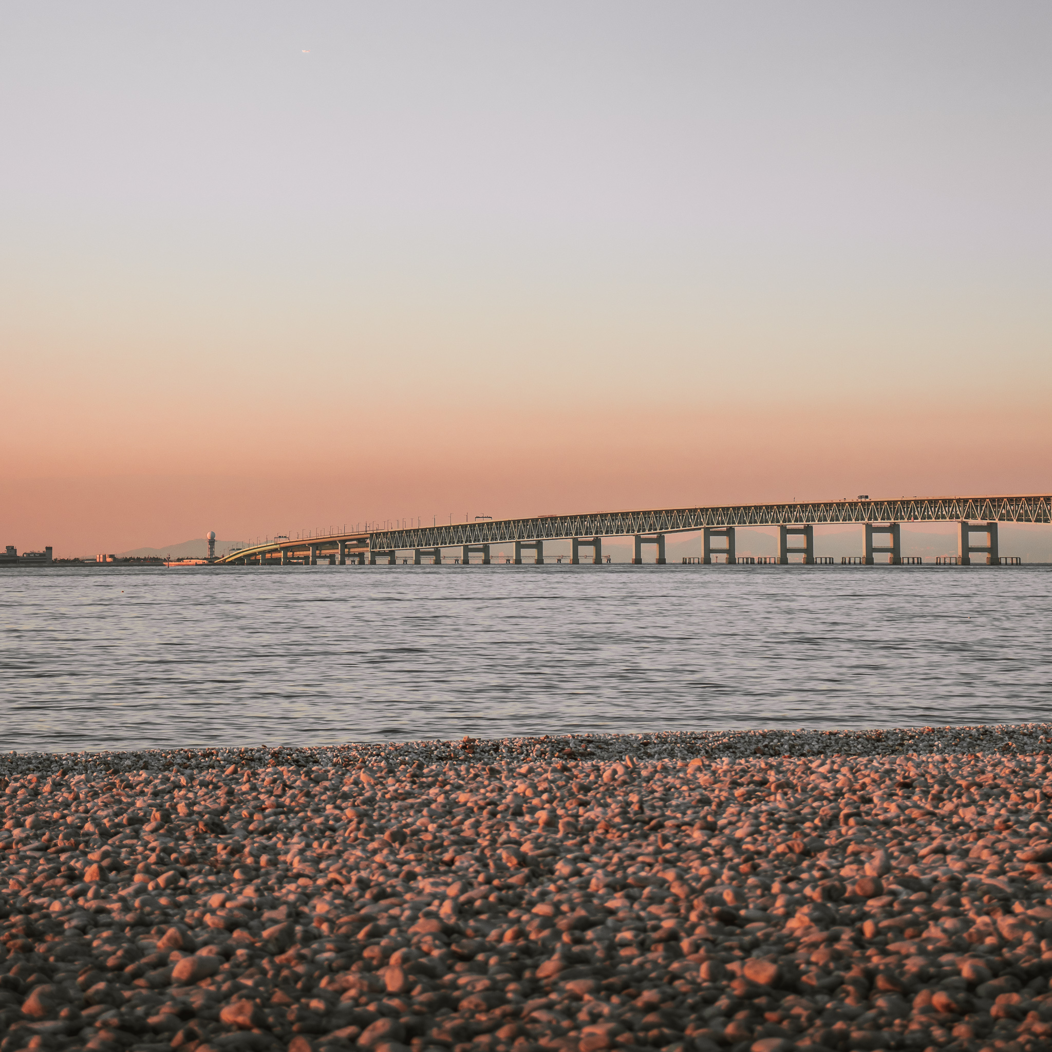 夕日に照らされているマーブルビーチと田尻スカイブリッジ