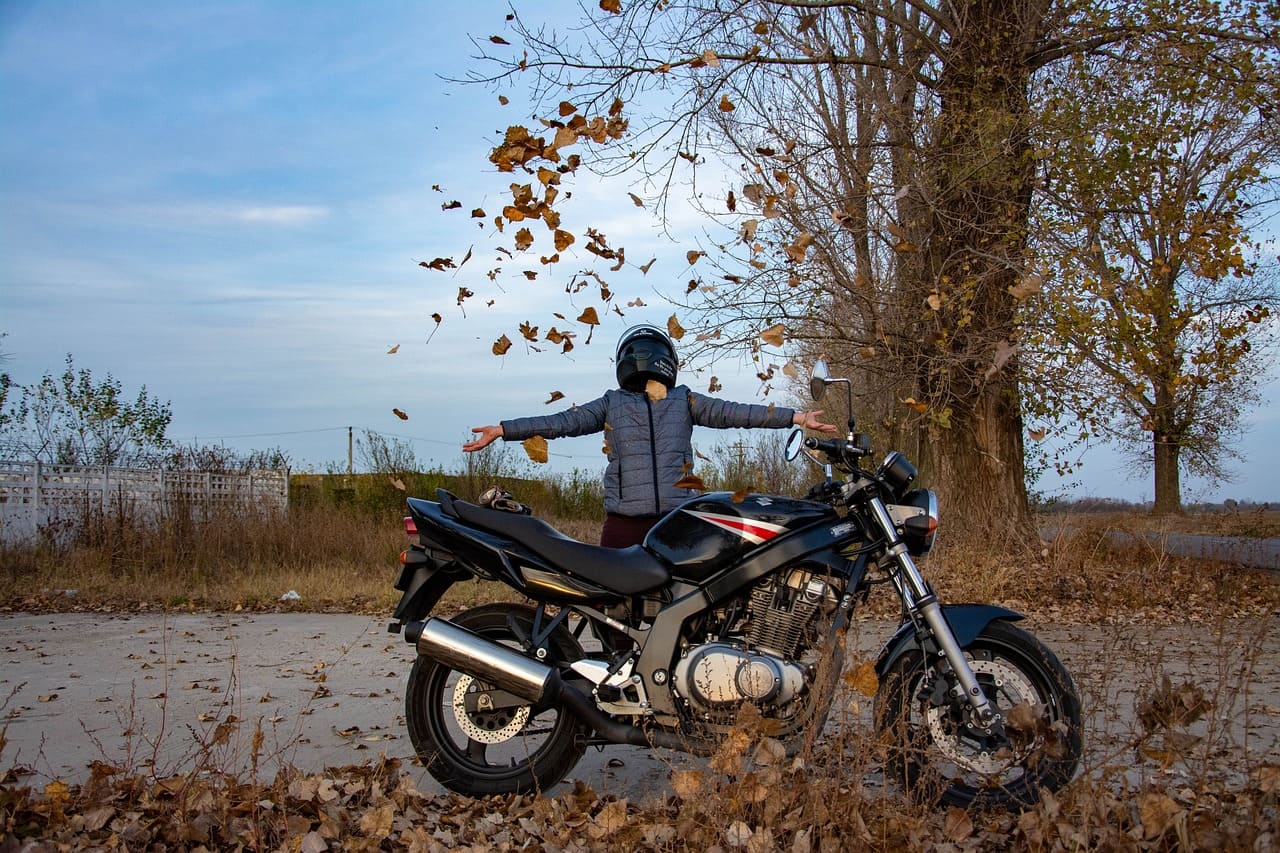 バイクの後ろで落ち葉を撒いているライダー