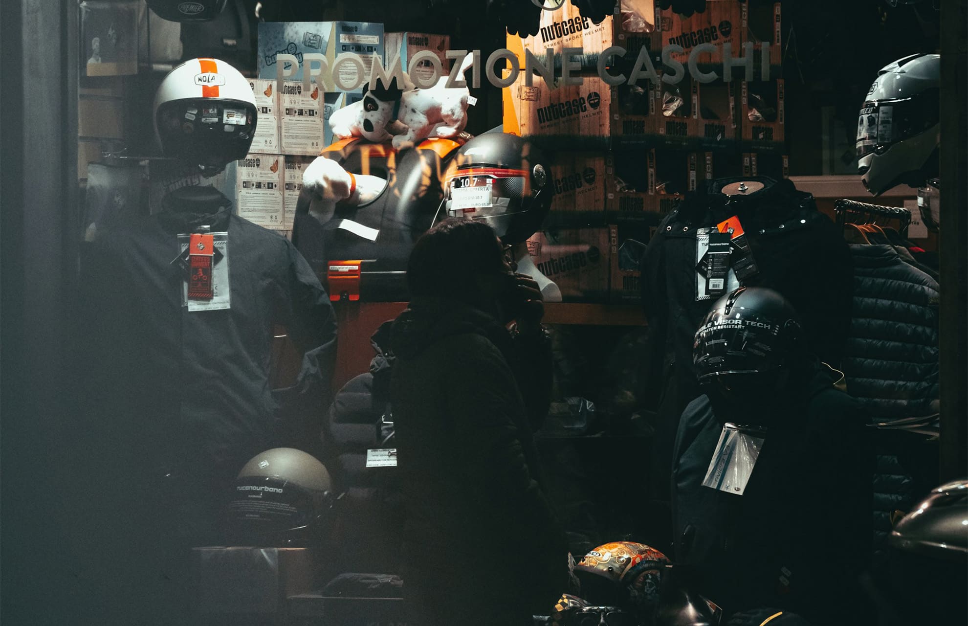 バイク用品店の前で悩んでいる人