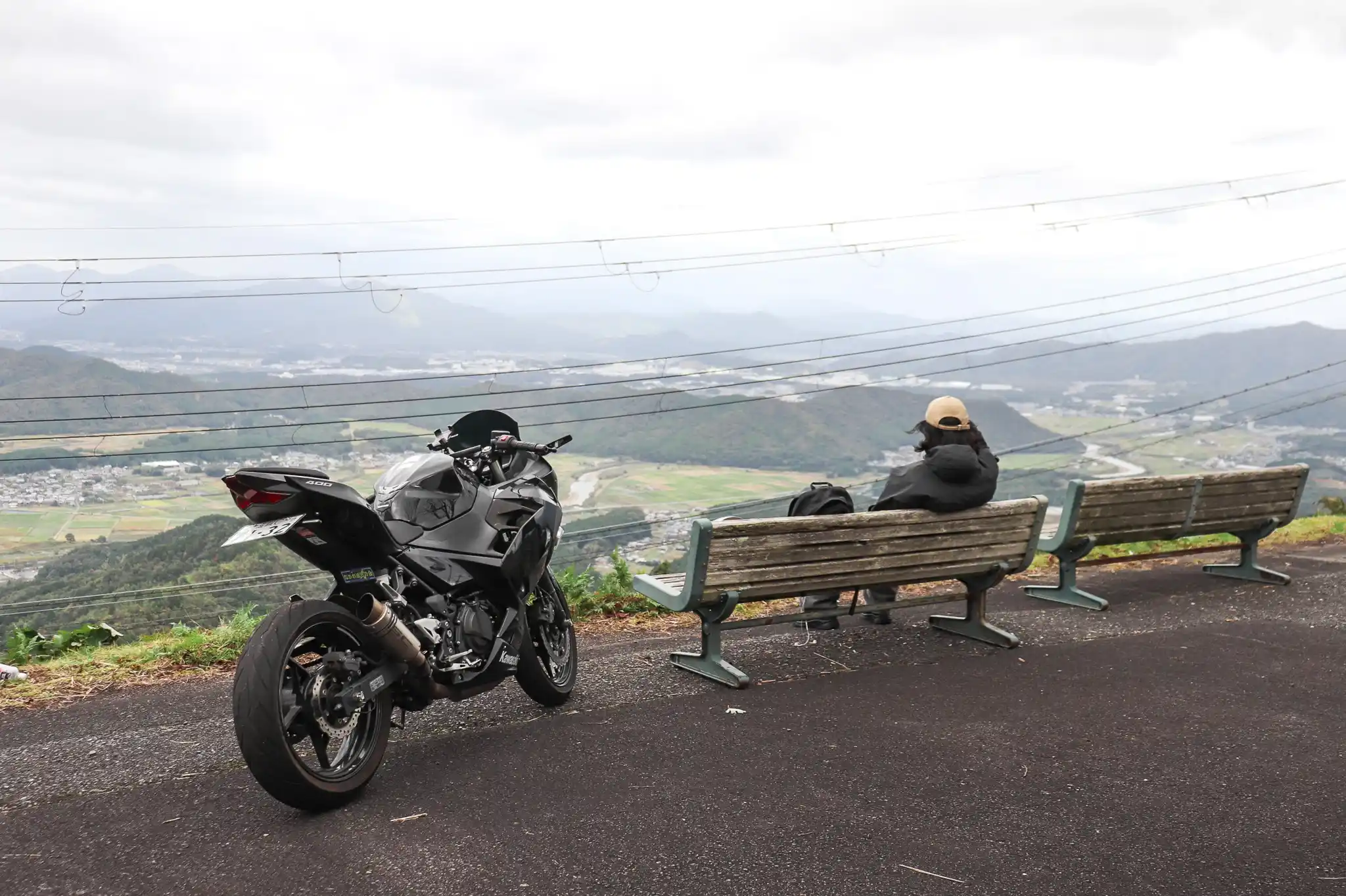 高谷山（横峰山）山頂の景色を眺める帽子を被った男性とNinja400