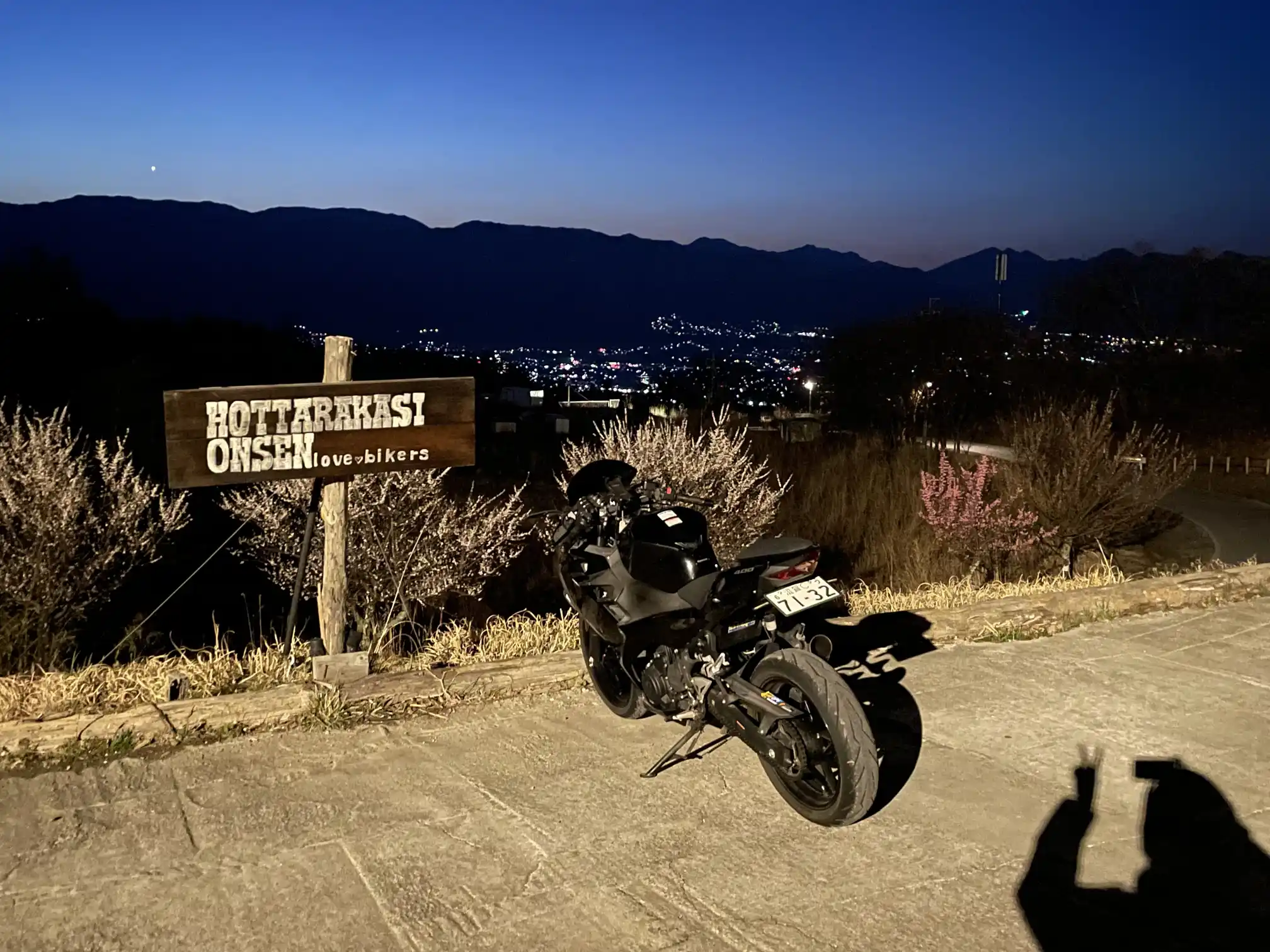 ほったらかし温泉のバイク駐車場に停まっている黒のバイクと夜景