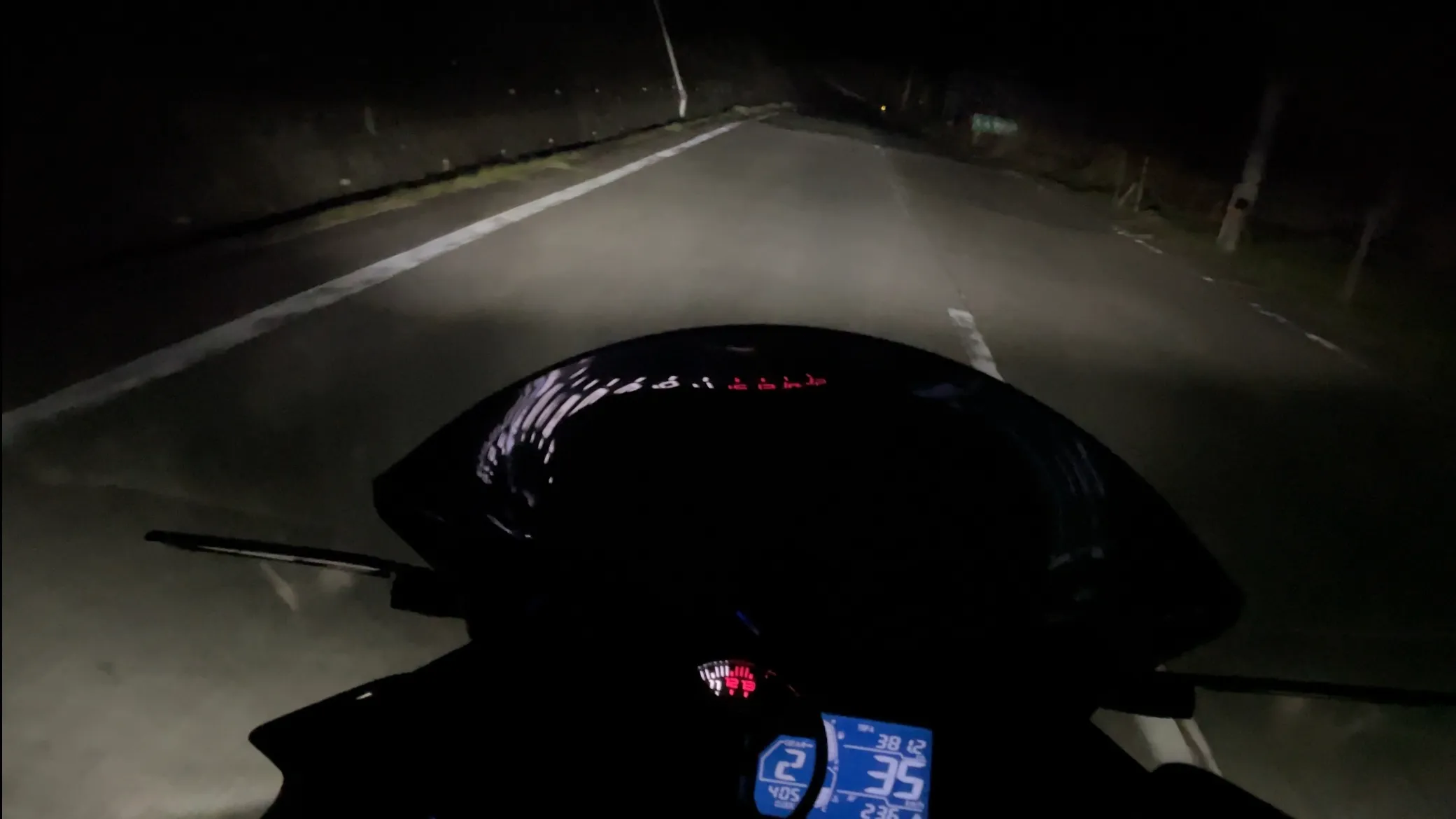暗い道路でバイクを運転しているライダー目線